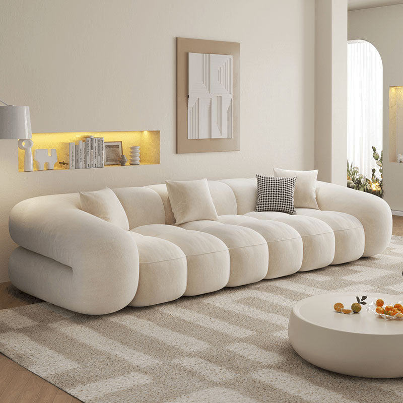 A beautifully decorated living space featuring a modern sofa, stylish cushions, a coffee table with decorative items, and a vibrant rug, creating a cozy and inviting atmosphere for a new apartment