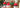 Close-up of a gift-wrapped present with a red bow under the Christmas tree.