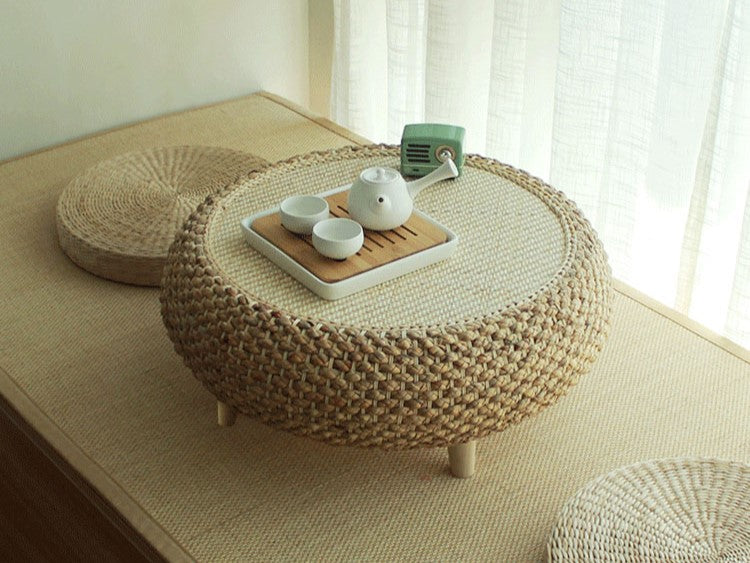 A minimalist living room with a low wooden platform bed and neutral-colored tatami mat, embodying Japanese-inspired decor